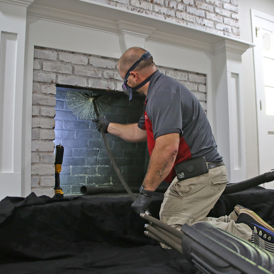 Chimney service professional sweeping a residential fireplace in Seattle, Washington