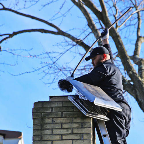 Chimney professional working beside a chimney crown and cap